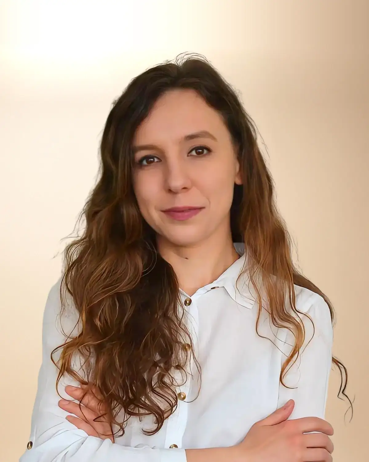 Agnieszka Krause, neurologopeda, w białej koszuli, z długimi falowanymi włosami