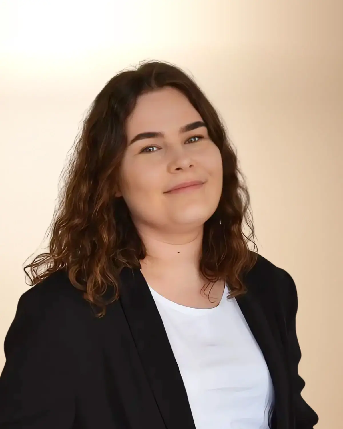 Hanna Szamatowicz, neurologopeda, w czarnej marynarce, z kręconymi włosami, uśmiechnięta