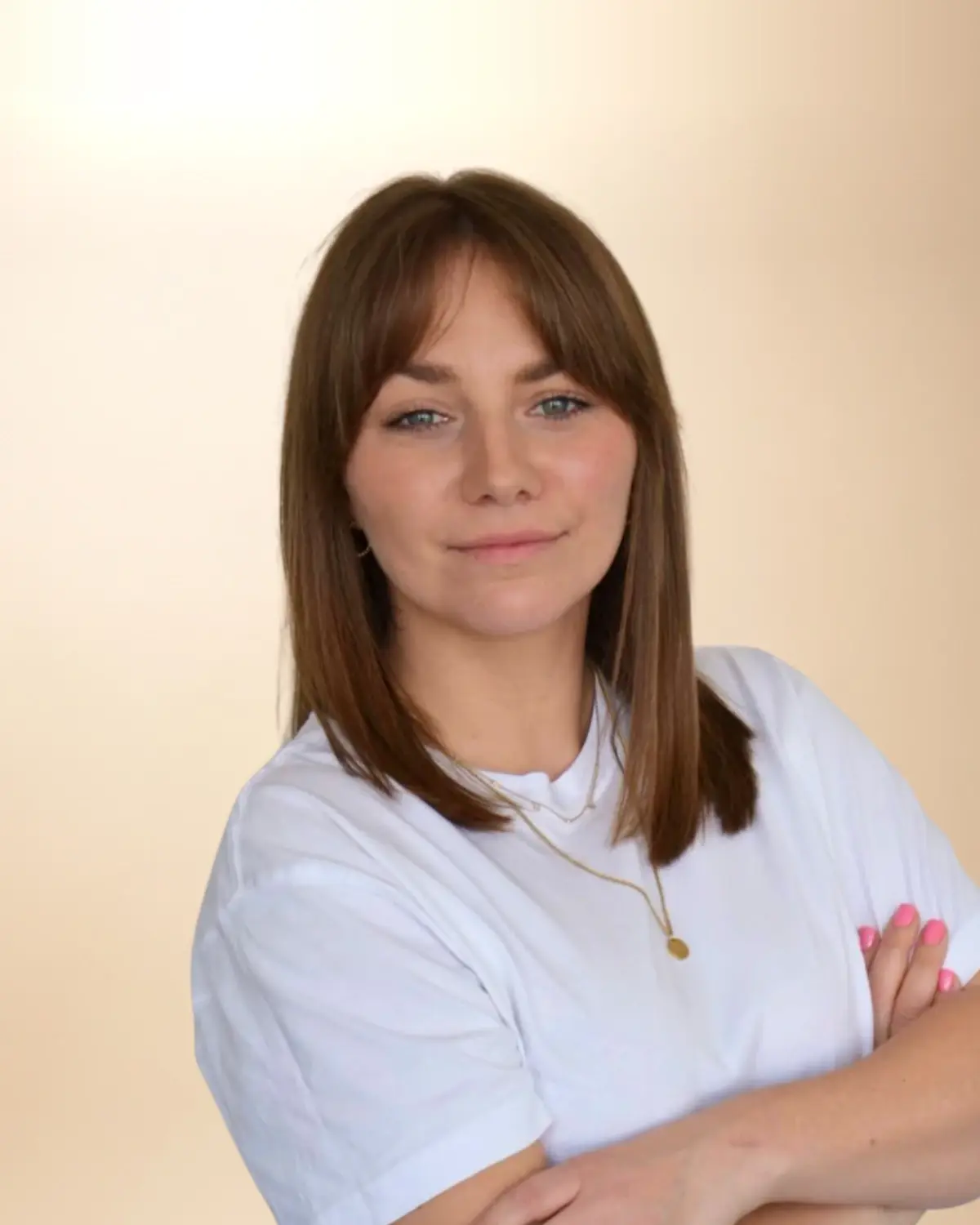 Katarzyna Woskowicz, logopeda i psycholog, w białej koszulce, z prostymi włosami i grzywką