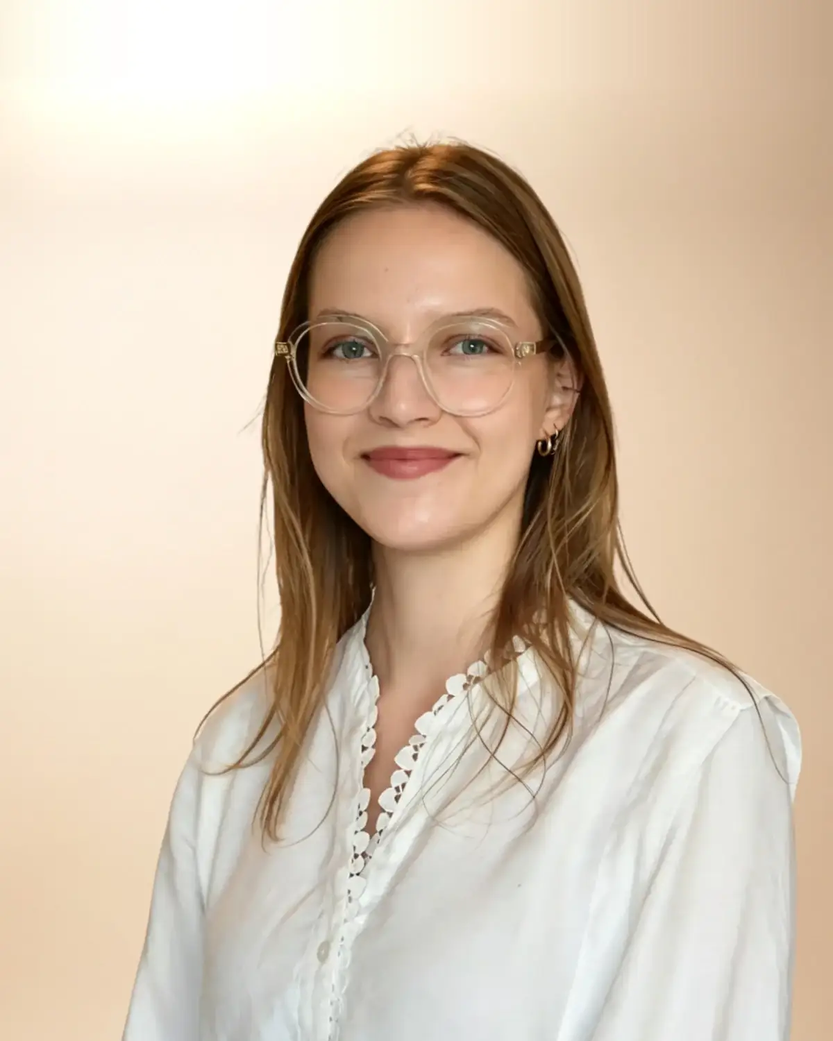 Paulina Chwiłka, psycholog, w białej koszuli i jasnych okularach, uśmiechnięta