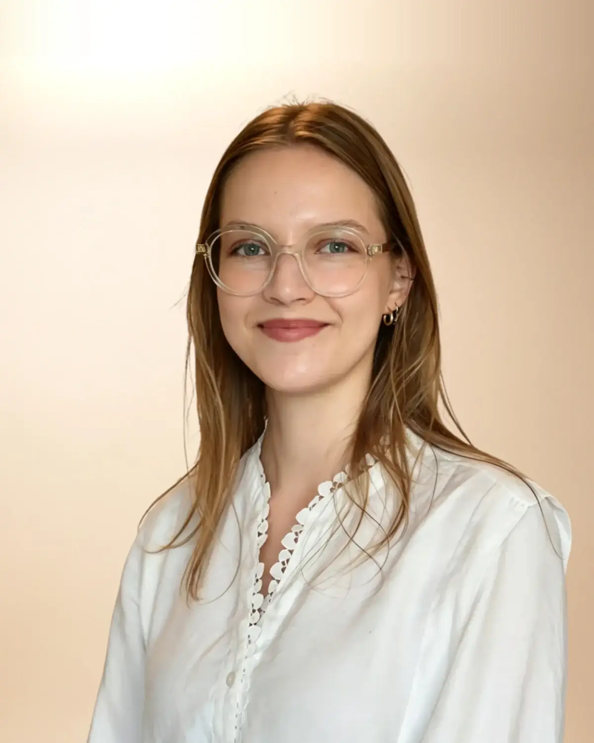 Paulina Chwiłka, psycholog, w białej koszuli i jasnych okularach, uśmiechnięta